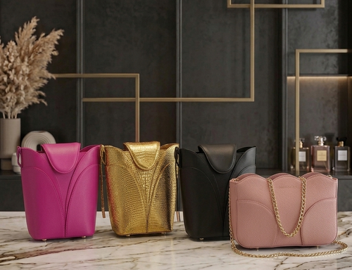 Four colorful handbags on a marble surface with a dark wall and decorative elements in the background.